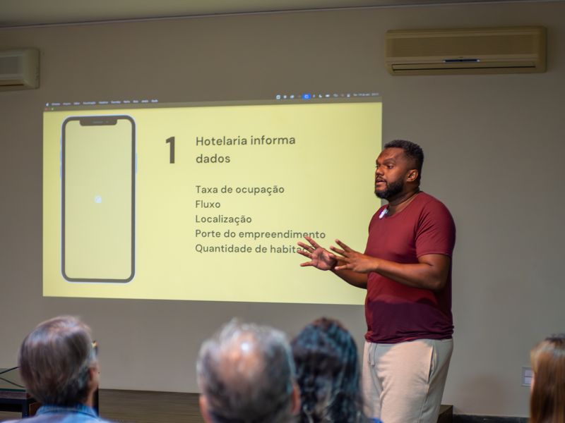 Thiago Acerola em palestra, explicando método na tela para empresários